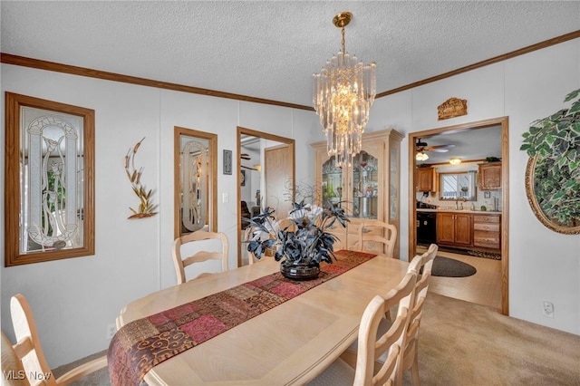 carpeted dining room with a textured ceiling, ornamental molding, and a chandelier