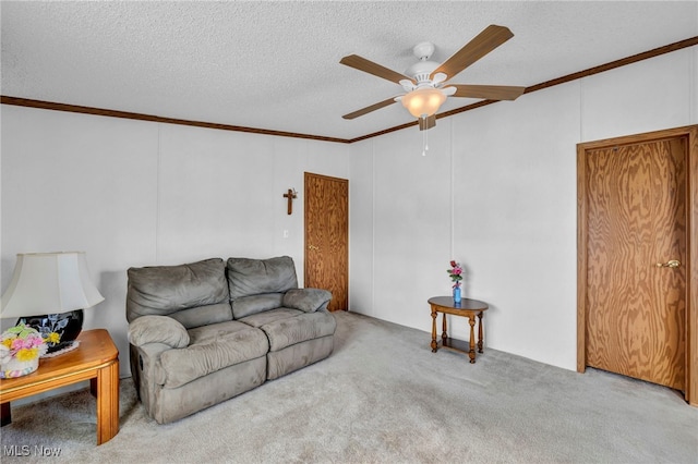 living room with ceiling fan, crown molding, light carpet, and a textured ceiling