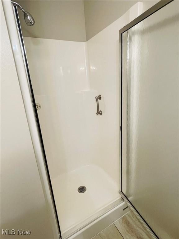 bathroom with a shower with door