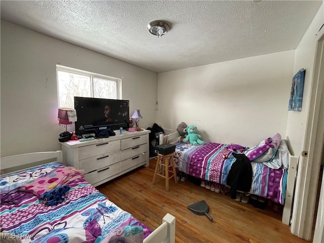 bedroom with dark hardwood / wood-style flooring and a textured ceiling