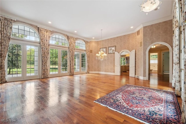 unfurnished living room with a high ceiling, ornamental molding, and light hardwood / wood-style floors