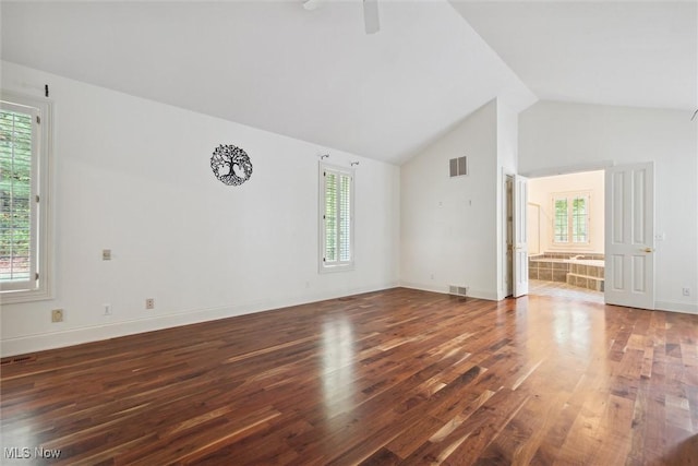 unfurnished living room featuring ceiling fan, a wealth of natural light, dark hardwood / wood-style flooring, and lofted ceiling