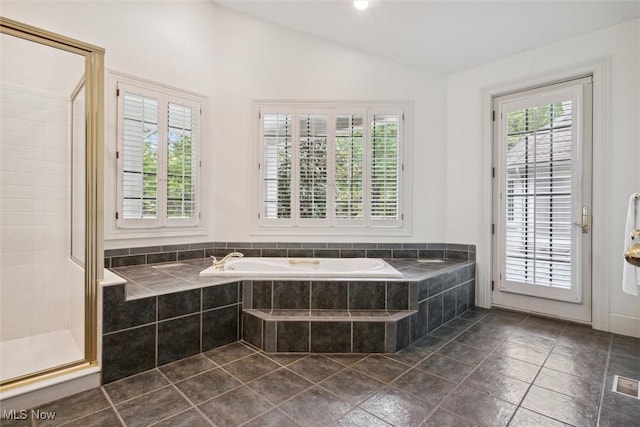 bathroom with independent shower and bath, vaulted ceiling, and a healthy amount of sunlight