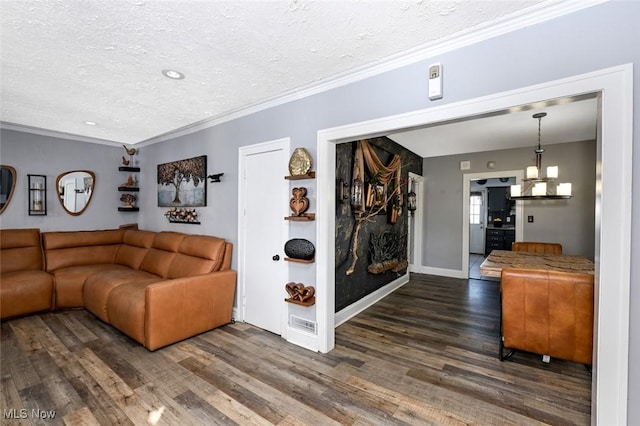 living room featuring dark wood-type flooring, a textured ceiling, and ornamental molding