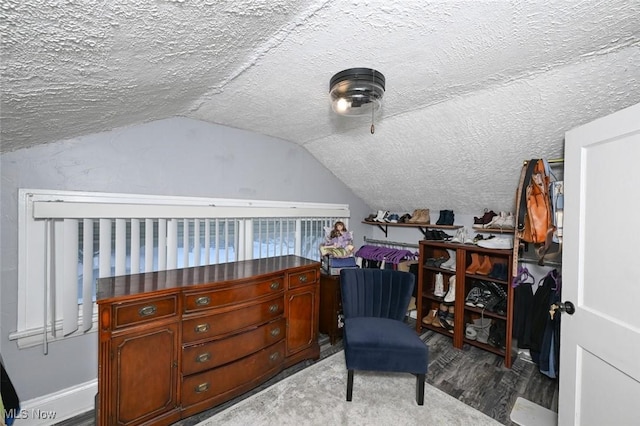 living area featuring hardwood / wood-style floors, vaulted ceiling, and a textured ceiling