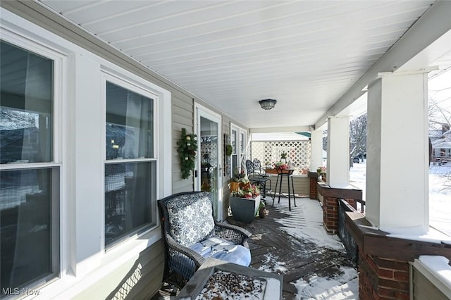 snow covered patio with a porch