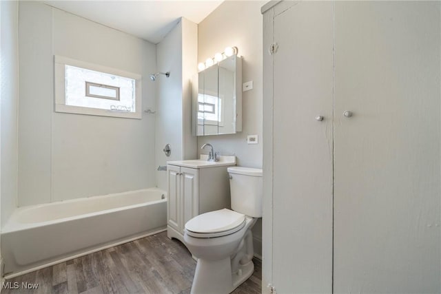 full bathroom featuring hardwood / wood-style floors, toilet, sink, and shower / bathing tub combination