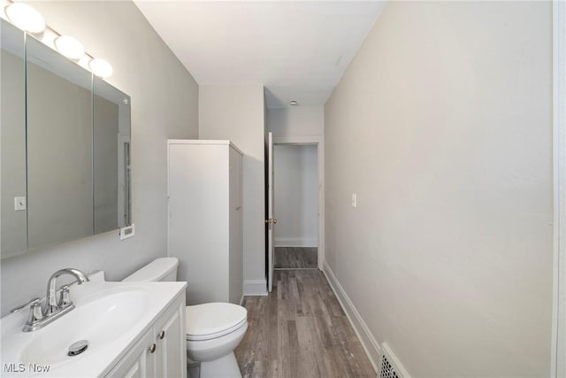 bathroom featuring hardwood / wood-style flooring, vanity, and toilet