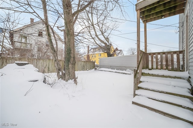 yard covered in snow with fence