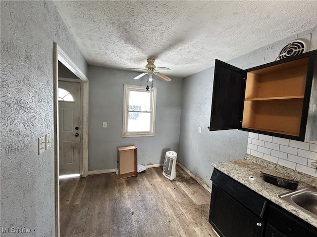 kitchen featuring a textured ceiling, decorative backsplash, ceiling fan, and light hardwood / wood-style floors