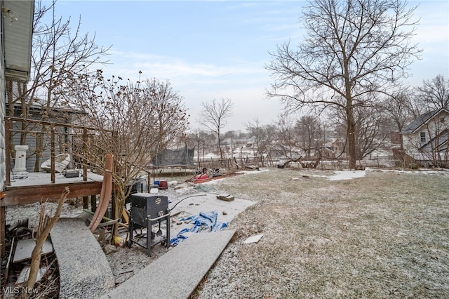 yard layered in snow featuring a trampoline