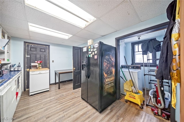 kitchen with light wood-type flooring, white dishwasher, a paneled ceiling, and black fridge with ice dispenser