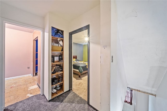 hallway featuring dark colored carpet