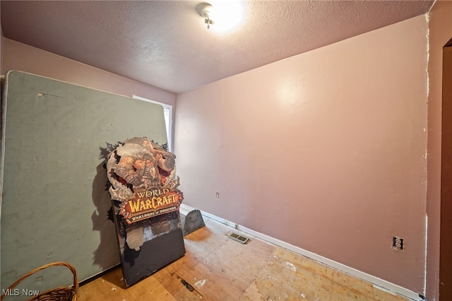 unfurnished room featuring a textured ceiling