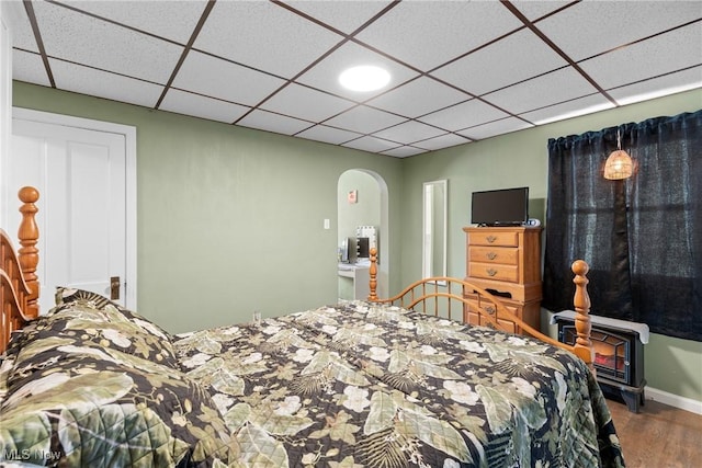 bedroom with a paneled ceiling and hardwood / wood-style flooring