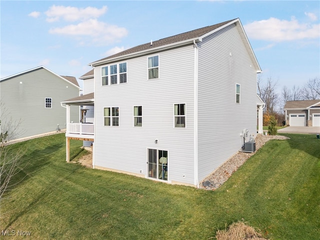 rear view of property featuring a yard and central AC unit