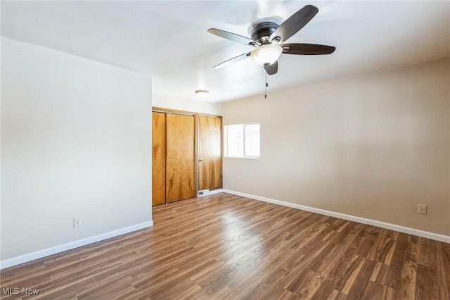 unfurnished bedroom with ceiling fan, a closet, and dark hardwood / wood-style flooring