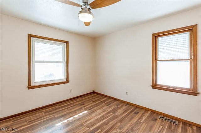 spare room featuring ceiling fan and dark hardwood / wood-style flooring