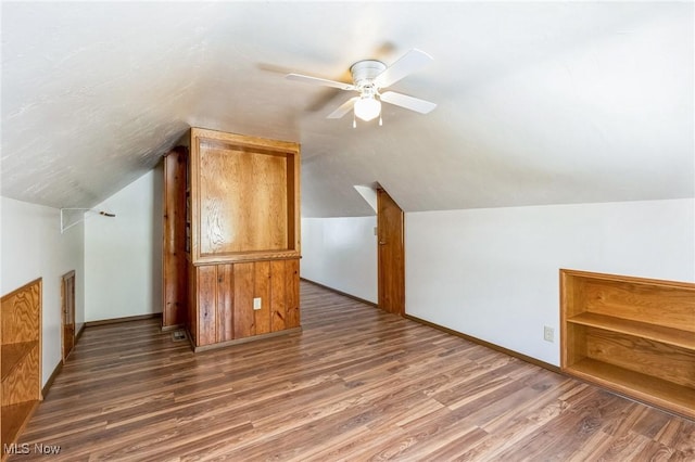 bonus room with ceiling fan, lofted ceiling, and dark hardwood / wood-style flooring