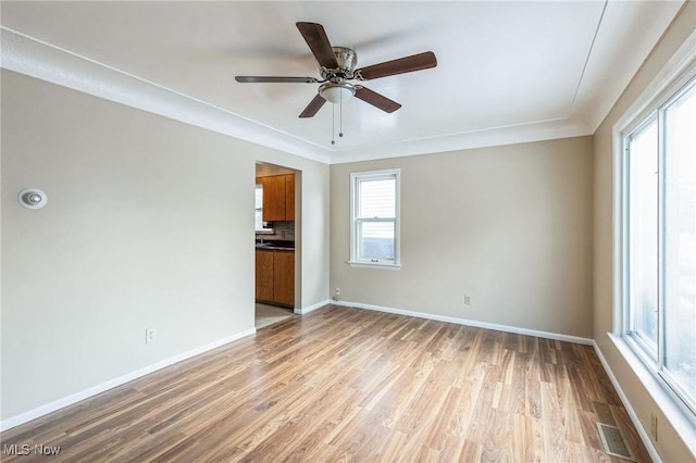 empty room with light hardwood / wood-style flooring and ceiling fan