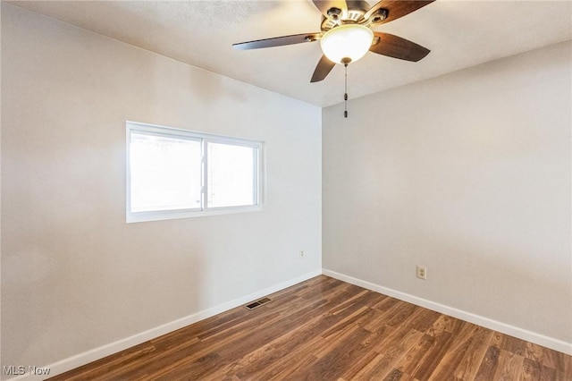 spare room featuring dark hardwood / wood-style floors and ceiling fan