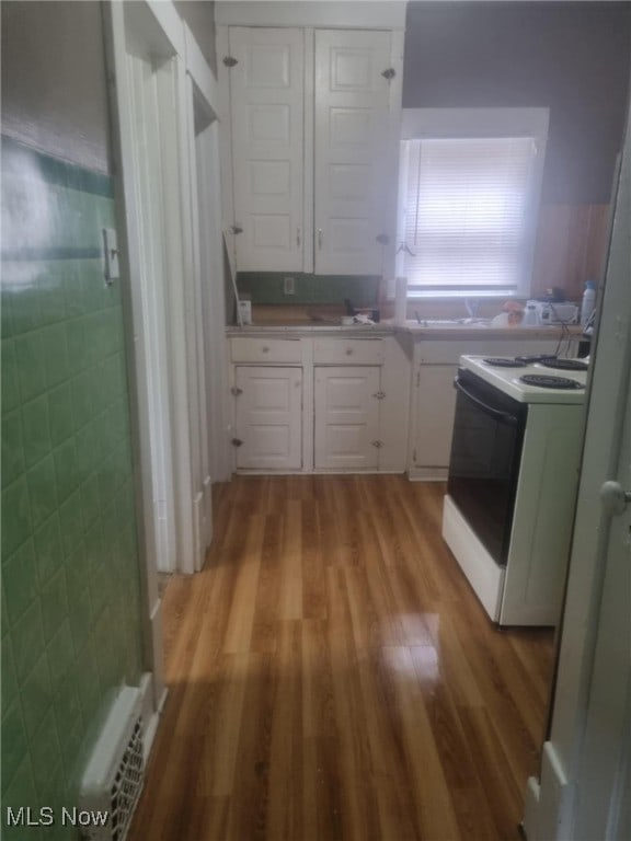 847 Sherman St, Akron, OH 44311 - kitchen featuring white cabinetry, white electric stove, light wood finished floors, and light countertops