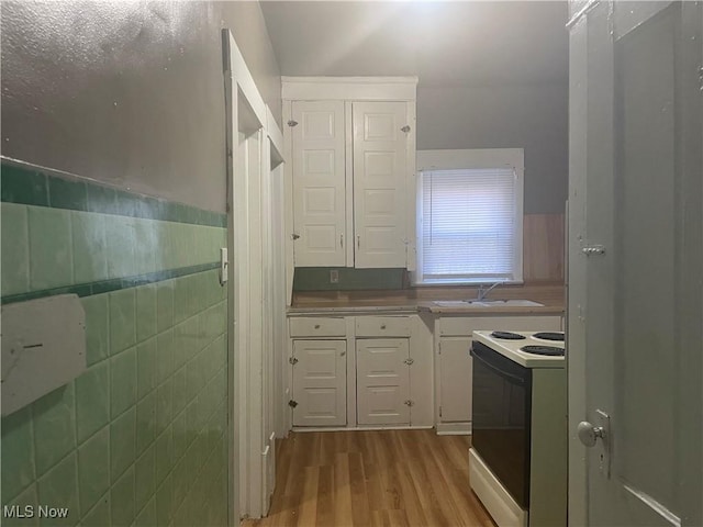 847 Sherman St, Akron, OH 44311 - kitchen featuring white cabinets, electric range oven, wood finished floors, and a sink