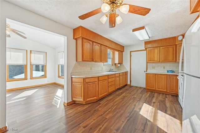 kitchen featuring light countertops, wood finished floors, freestanding refrigerator, and decorative backsplash