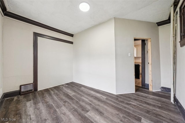 unfurnished room featuring a textured ceiling and dark hardwood / wood-style floors