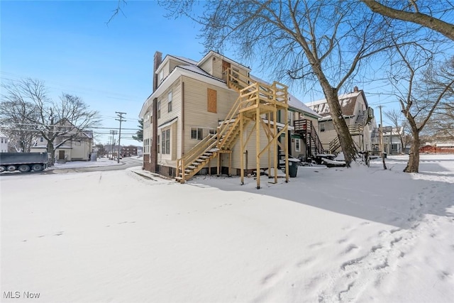 view of snow covered rear of property