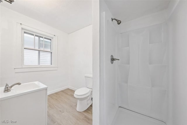 bathroom featuring hardwood / wood-style flooring, vanity, toilet, and walk in shower