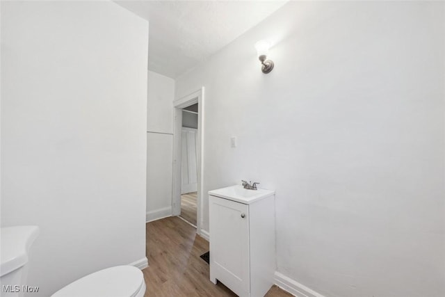 bathroom featuring wood-type flooring, sink, and toilet