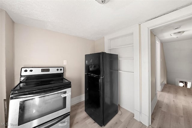 kitchen featuring black refrigerator, light hardwood / wood-style flooring, vaulted ceiling, a textured ceiling, and stainless steel range with electric stovetop