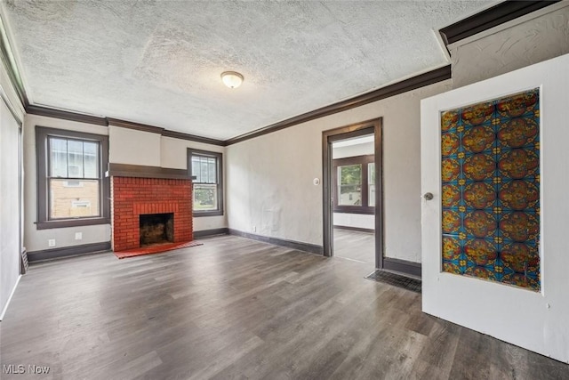 unfurnished living room featuring dark hardwood / wood-style flooring, plenty of natural light, a textured ceiling, and a brick fireplace