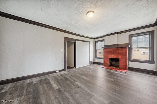 unfurnished living room with a textured ceiling, dark hardwood / wood-style flooring, ornamental molding, and a fireplace