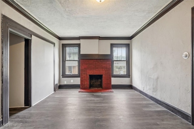 unfurnished living room featuring a textured ceiling, dark wood-type flooring, a brick fireplace, and crown molding