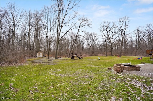 view of yard featuring a storage unit and an outdoor fire pit