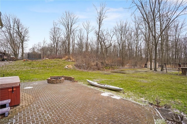 view of patio featuring an outdoor fire pit and a trampoline