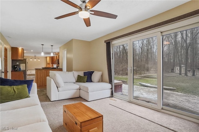 living room with ceiling fan, light colored carpet, and plenty of natural light