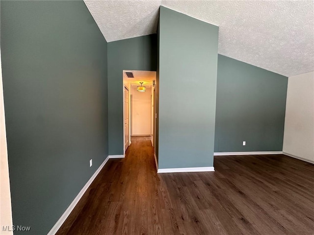 bonus room with dark hardwood / wood-style flooring, a textured ceiling, and lofted ceiling