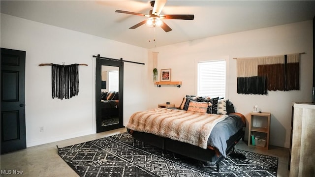 bedroom with ceiling fan and a barn door