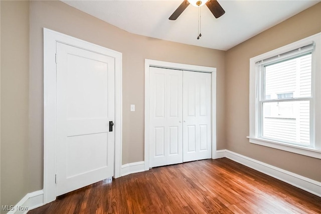 unfurnished bedroom with hardwood / wood-style flooring, ceiling fan, and a closet