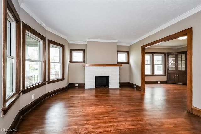 unfurnished living room featuring a brick fireplace, crown molding, and dark hardwood / wood-style floors