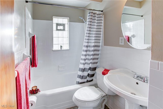 full bathroom featuring toilet, shower / tub combo, a sink, and tile walls