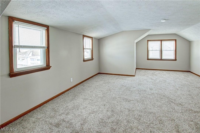 bonus room with a textured ceiling, carpet, and baseboards