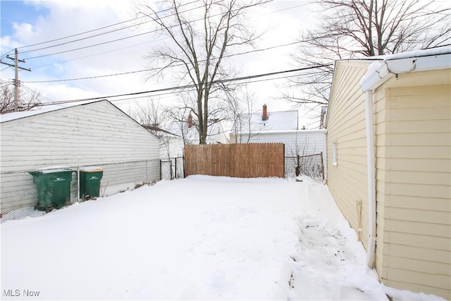 yard layered in snow featuring fence