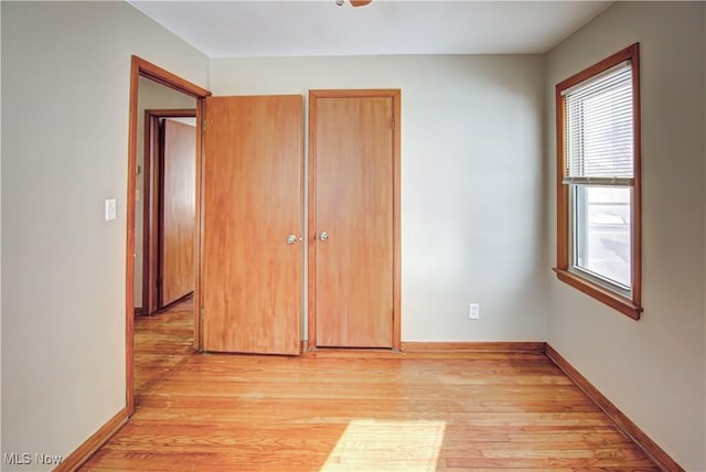 unfurnished bedroom with light wood-type flooring and baseboards