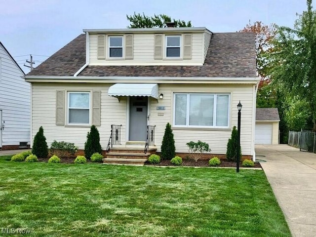 bungalow-style home with roof with shingles, a front lawn, and an outbuilding