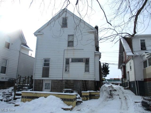 view of snow covered rear of property