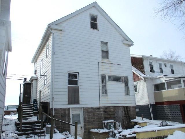 view of snow covered rear of property